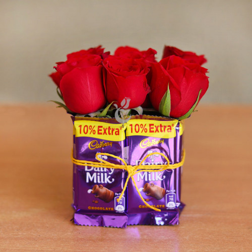 combo of 9 Red roses with 8 Dairy Milk in a square vase